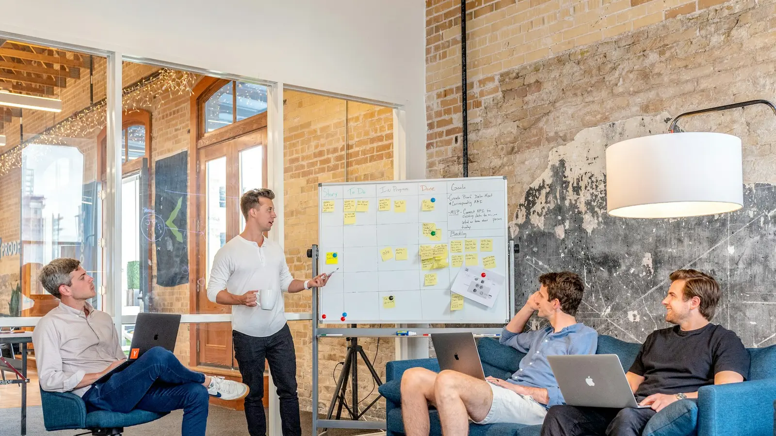 Team working on laptops in front of a whiteboard during a working session